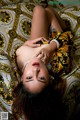 A woman laying on top of a bed covered in a blanket.