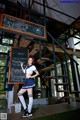 A woman in a school uniform standing in front of a blackboard.