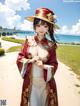 A woman in a red and white kimono standing on a beach.